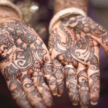Outstretched hands are decorated with henna