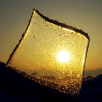 A piece of broken glass with sun shining through it.