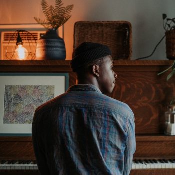 A young man sitting at a piano looking to his right