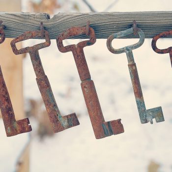 A group of rusty keys hung from a board