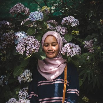 Woman standing among flowers.