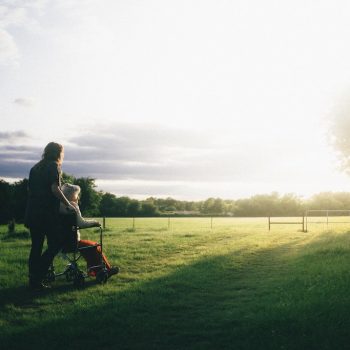 two people watching the sun, one in a wheelchair