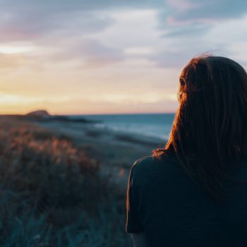 a person gazing down a coastal beach