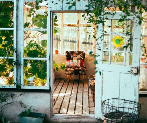 Plants hanging in a sunny sunroom doorway