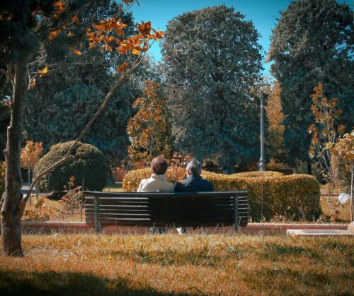 A couple sitting on a bench in autumn
