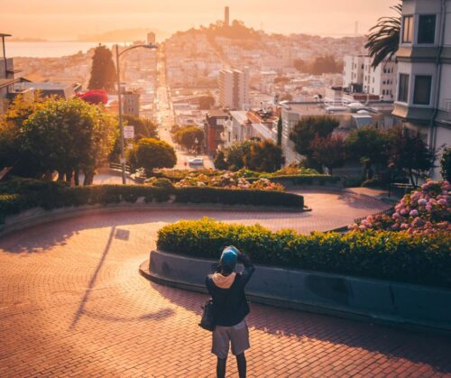 A person taking a photo from the top of a winding brick road in San Francisco