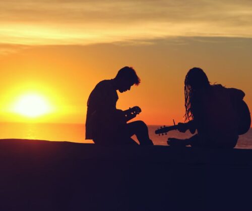 Silhouette of man and woman playing guitars