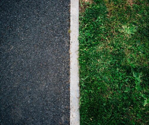 A birds eye photo split in half with asphalt on the left and grass on the right