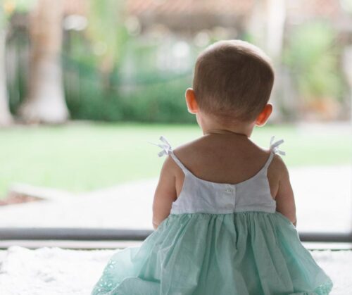 Photo of a toddler in a white and green dress
