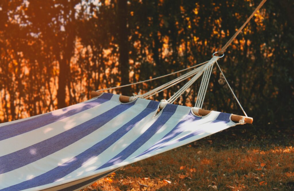 Blue and white hammock at sunset during golden hour